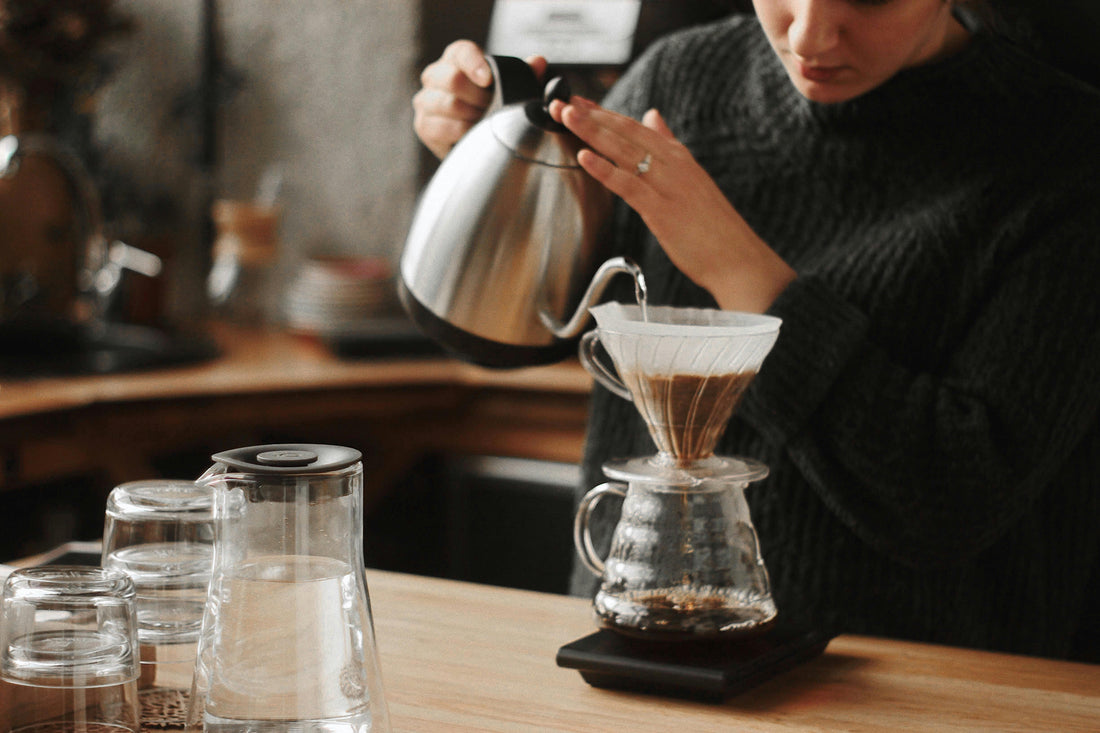 Handfilter-Aufguss mit Schwanenhalskessel im V60 auf Glaskanne – Zubereitung von Filterkaffee.