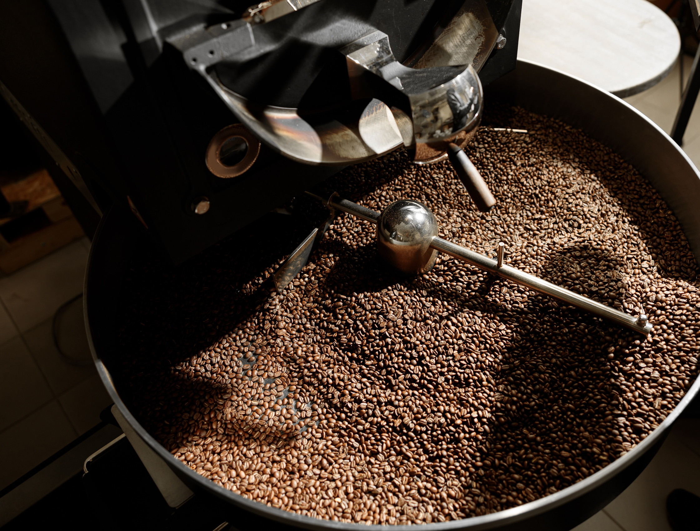 Coffee Processing. Roastery, Roasting Machine and Fresh Beans